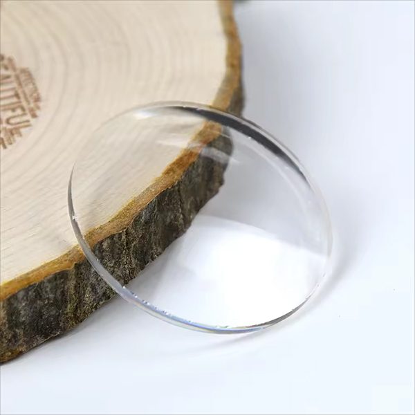 A clear Super White mineral glass lens resting against a slice of wood