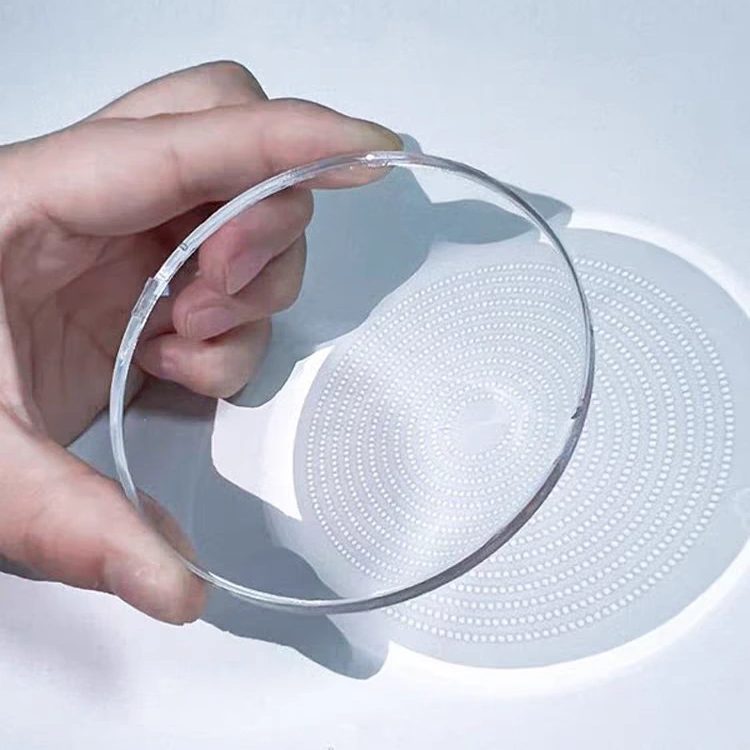 A hand holding a 1.591 PC myopia control lens, the microlens dot pattern visible against a white background
