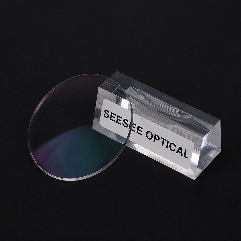 A Trivex lens standing in a clear acrylic block engraved Seesee Optical, dark background
