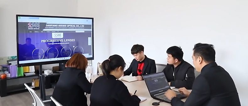 A team meeting around a table in front of a large screen