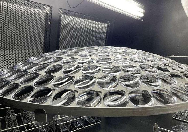 A loaded coating dome holding dozens of lenses before vacuum coating