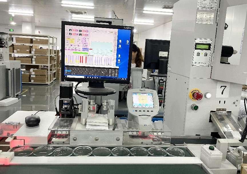 A packing machine with a monitor and a row of lens envelopes