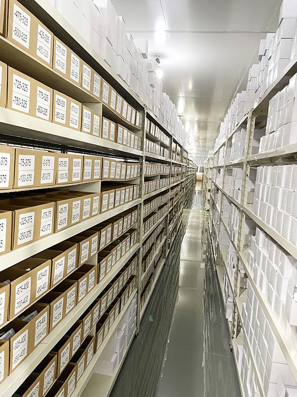 A long aisle of shelving stacked with labelled lens boxes